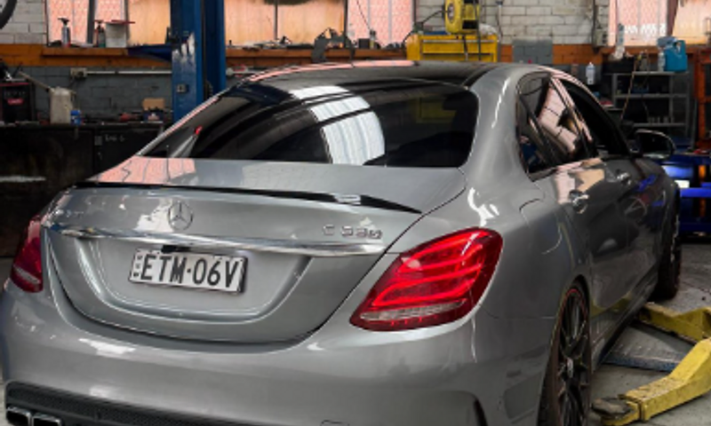Silver Mercedes-AMG C63 on the hoist inside the Karims Auto Repairs workshop