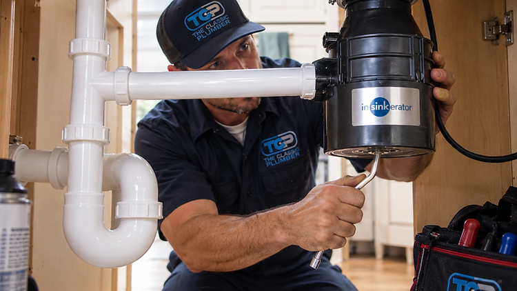 Using an Allen wrench to free a jammed garbage disposal flywheel