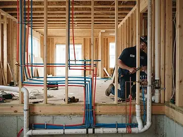 New construction plumbing rough-in with PEX water lines and PVC drain pipes
