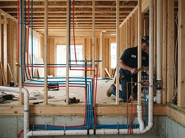 New construction plumbing rough-in with PEX water lines and PVC drain pipes