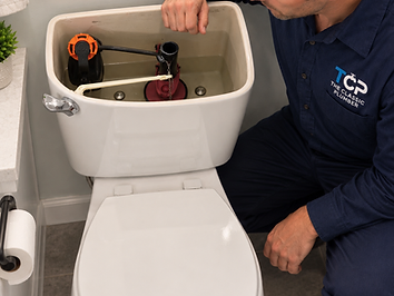 Professional plumber repairing a residential toilet in a clean bathroom