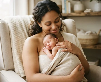 A parent cuddling a sleeping newborn