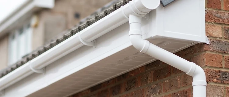 Newly installed uPVC guttering, fascia and soffit boards on the roofline of a British house