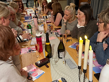 Women talking around a long candlelit table at a Fannies & Flapjacks event