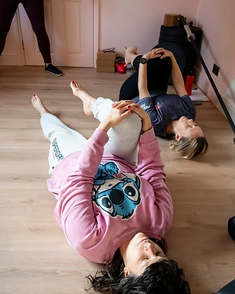 Two members stretching together on the gym floor