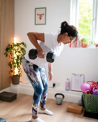 Member performing a dumbbell bent-over row in the studio