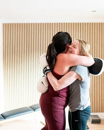 Two members sharing a laugh and a hug after training