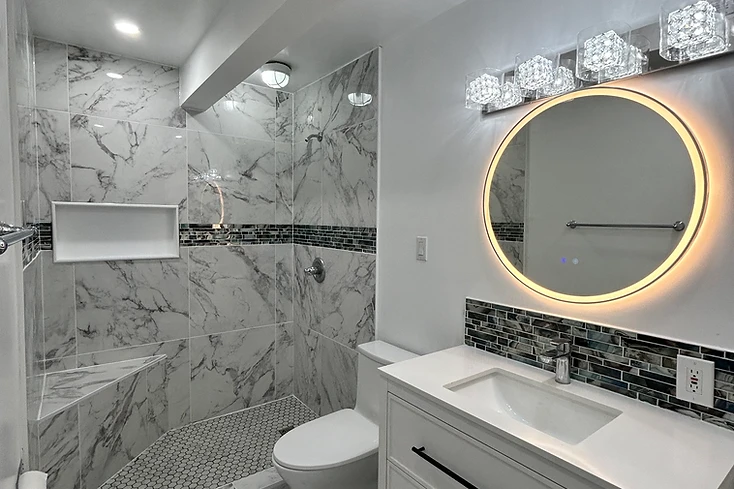 Completed bathroom renovation with tiled walk-in shower and vanity