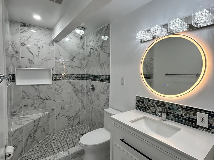 Completed bathroom renovation with tiled walk-in shower and vanity