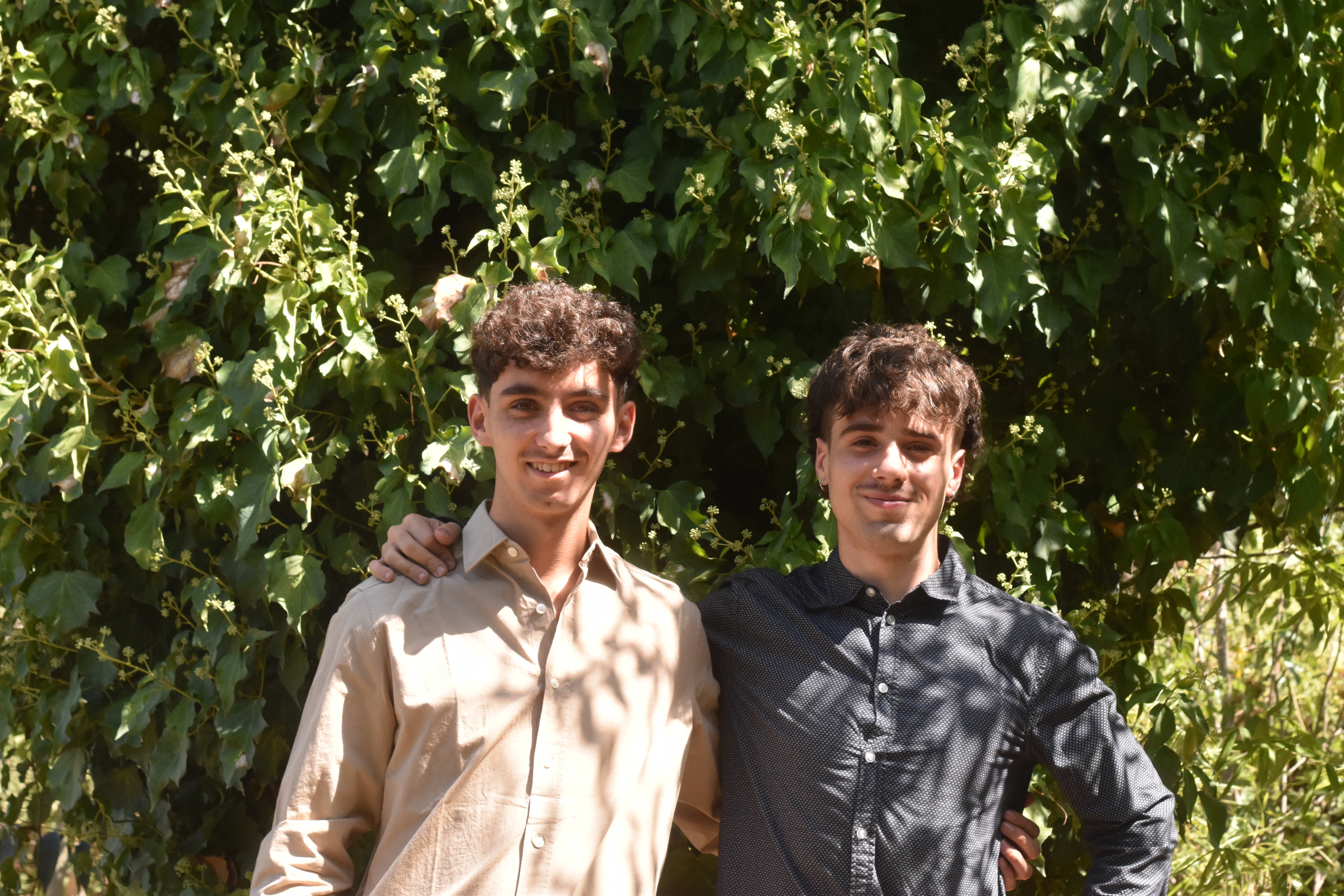 Dos membres de l'equip de lliga.cat davant d'una paret d'heura