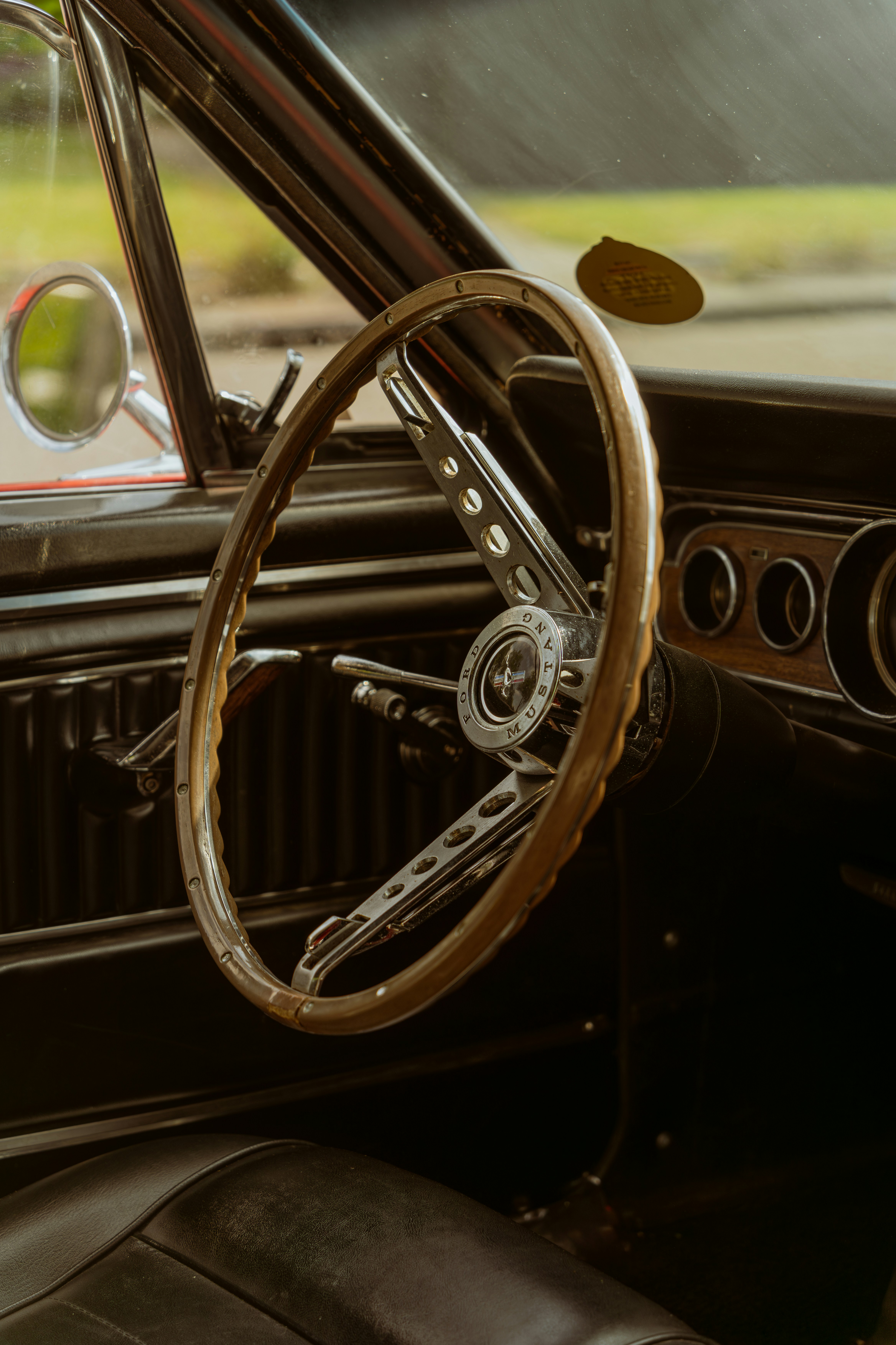 Classic Mustang interior — wooden steering wheel and chrome gauges