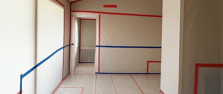 Technicians in PPE inside an organized containment