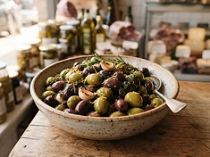Bowl of marinated green and black olives with herbs and garlic