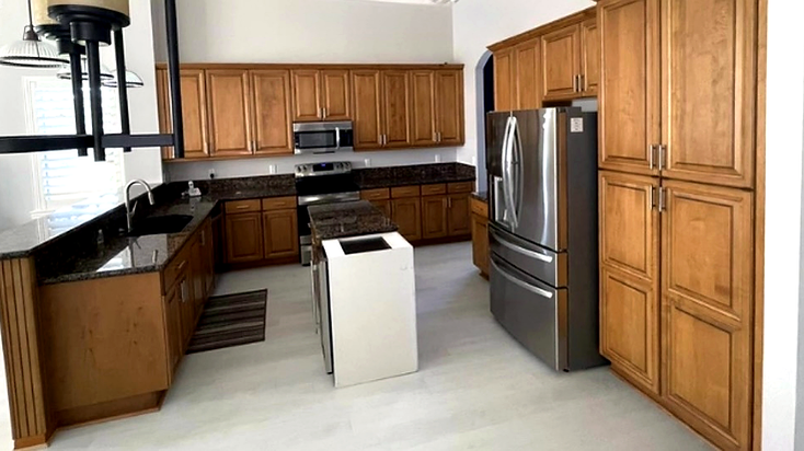 Kitchen before renovation with honey wood cabinets