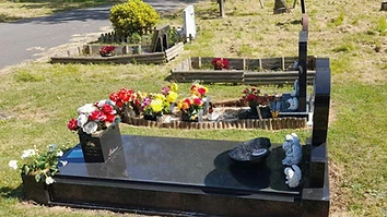 Decorated memorial site with flowers in a cemetery garden