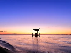 琵琶湖に立つ白鬚神社の鳥居。夕陽に染まる水面と空。