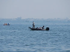 琵琶湖の水面に浮かぶ2隻のバスボート。遠くに霞む都市のスカイライン。