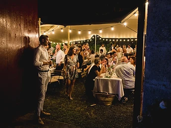 Soirée intime de mariage sous une tente stretch éclairée par des guirlandes la nuit