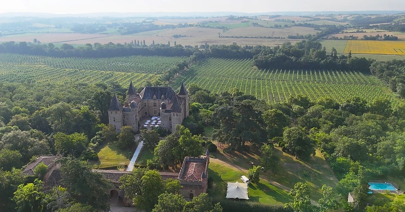 Vue aérienne d'un domaine viticole avec une tente stretch ouverte sur le paysage