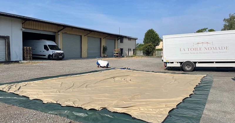 Camion et toile stretch déployée dans la cour de l'agence La Toile Nomade