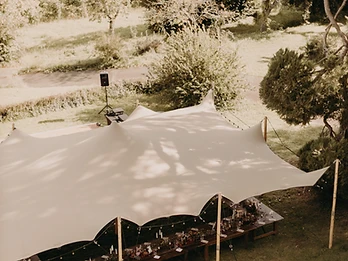 Tente stretch beige vue du dessus avec tables disposées en U et compositions florales