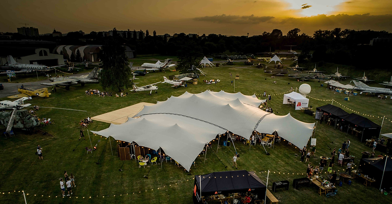 Tente stretch illuminée au coucher du soleil sur un site d'événement en plein air