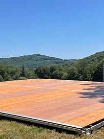 Plancher bois modulaire installé sur pelouse en pente, structure autoportante