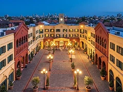 The piazza at dusk under globe lamps