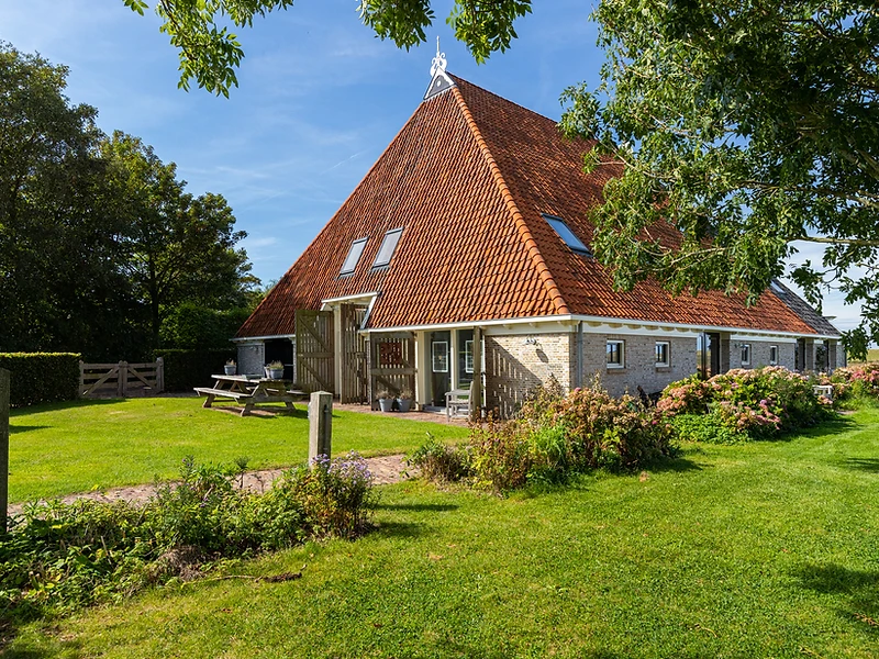 Exterieur van de Friese kop-rompboerderij Iselmarpleats in Gaast bij schemering, met het IJsselmeer aan de horizon