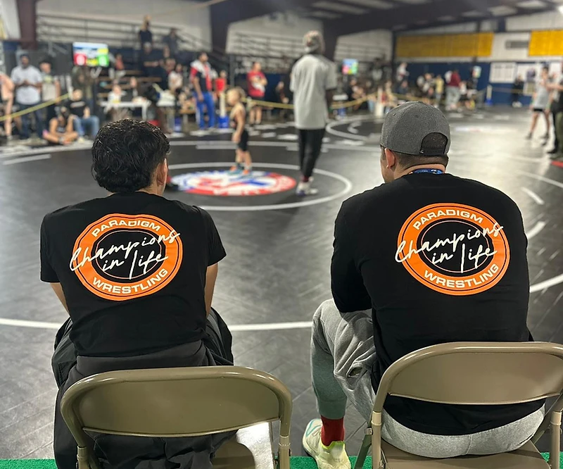 Paradigm® wrestlers watching a match from the sideline