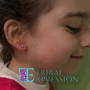 A child in profile with a clear gemstone stud earring in the earlobe.