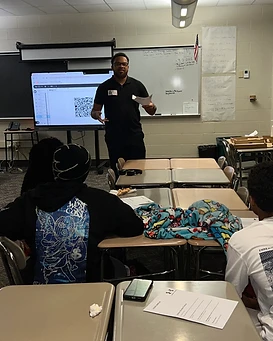 A BlueRobin workshop leader presenting to students in a classroom
