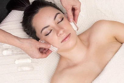 A therapist applying clear quartz crystal wands during a crystal light energy massage