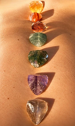Seven faceted chakra crystals placed in a vertical line along the spine