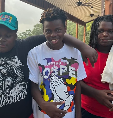 Three young men posing together on a covered patio