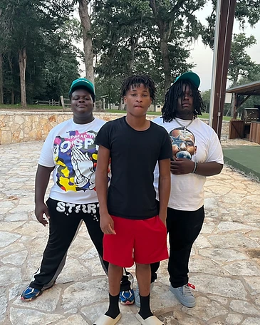 Three young men standing on a stone patio