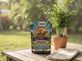 The ReptilesAway 32 oz pouch standing on a teak lanai table beside a potted palm in warm morning light