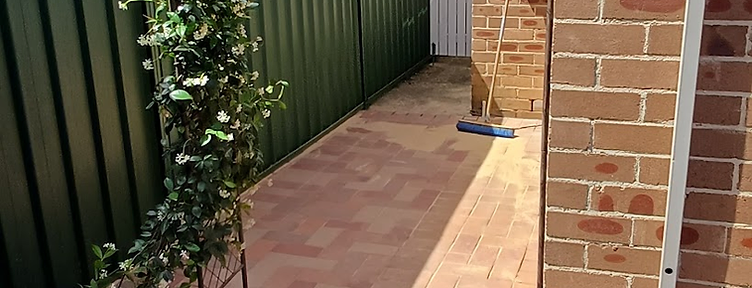 Completed herringbone brick paving side path with drainage grate