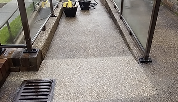 Finished pebblecrete patch with new drainage grate