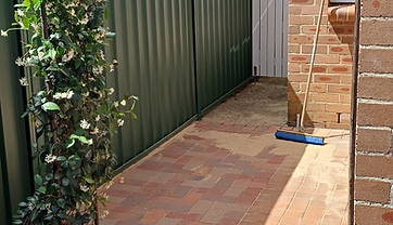 Completed brick paving side path leading to a rear gate