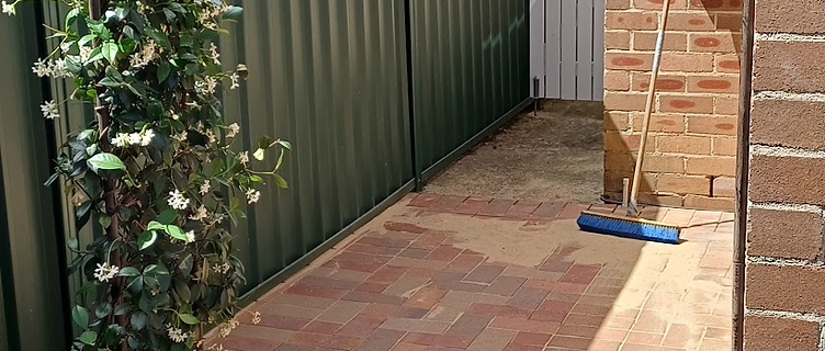 Finished brick paving path leading to a white gate