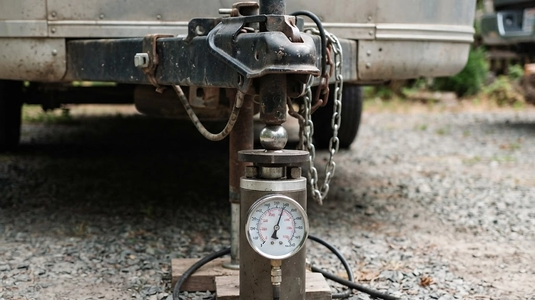 A tongue weight scale measuring the downward force of a loaded trailer on a hitch