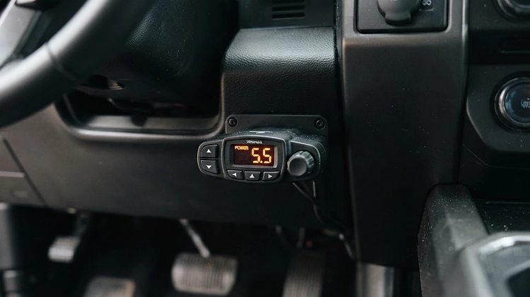 A close-up view of a proportional trailer brake controller mounted on the dashboard of a modern pickup truck.