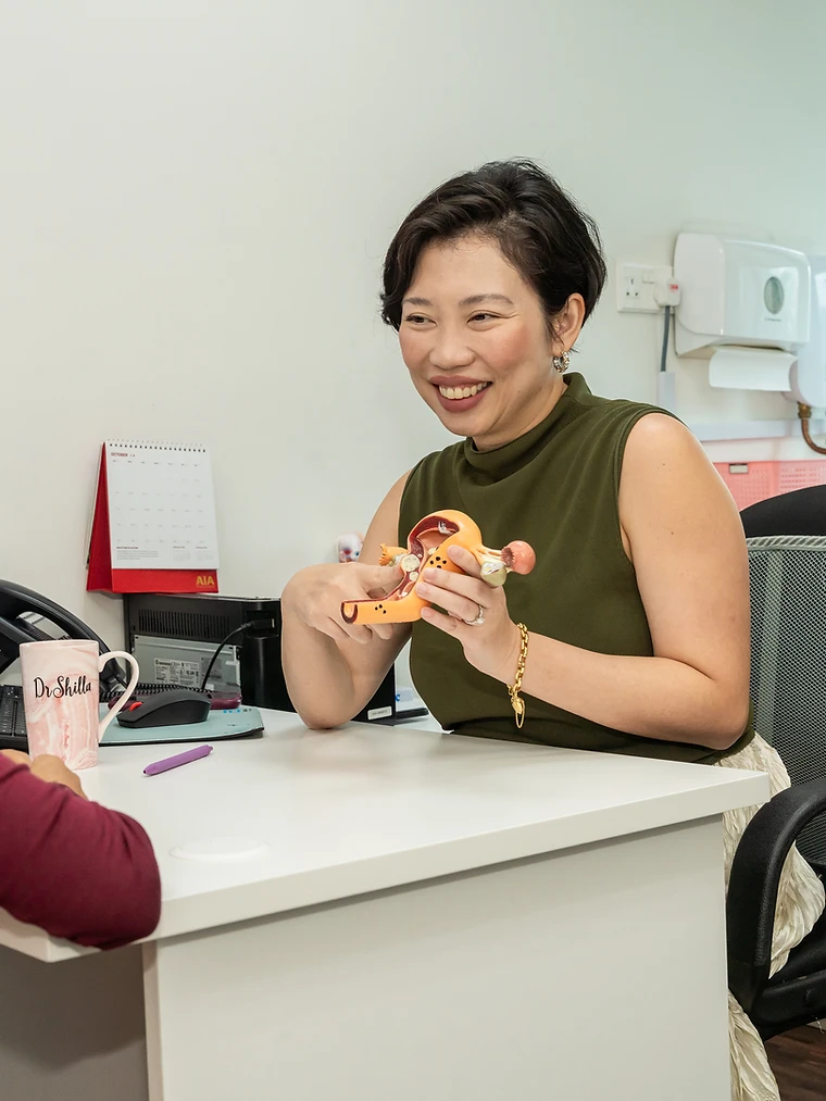 Dr Shilla Mariah explaining a uterine model during a fertility consultation