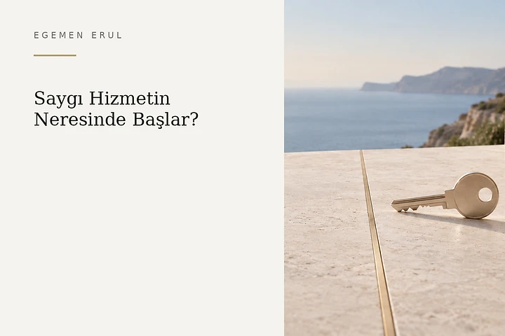Açık renkli Akdeniz taş terasında, ince şampanya renkli sınır çizgisinin hemen önünde duran mat metal anahtar; güveni, izni ve kişisel sınıra duyulan saygıyı simgeliyor.