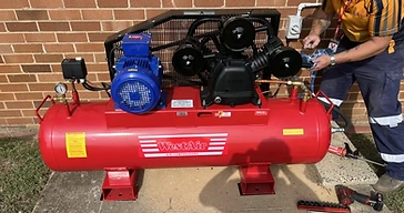 Technician repairing commercial air compressor for Emerald Air Compressors