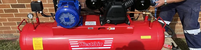 Technician repairing commercial air compressor for Emerald Air Compressors