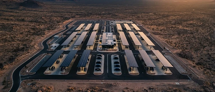 Top-down architectural view of a futuristic autonomous vehicle charging hub at sunset
