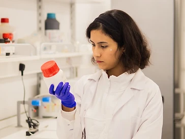 Lab technician holding a sample bottle in a laboratory
