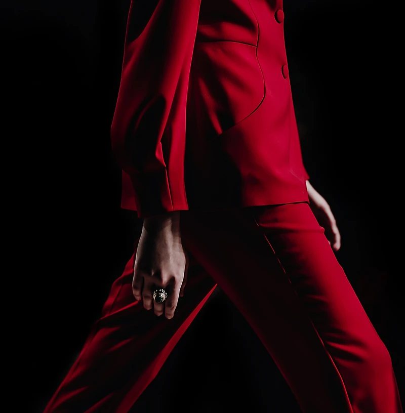 Founder in a red suit photographed against a black background